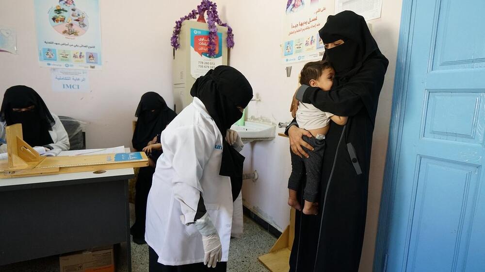A young mother and her baby are weighed before being examined for malnutrition at UNFPA-supported Marib General hospital in Yemen, a country that relies heavily on food imports. Skyrocketing food prices have increased the number of people in need of food assistance from 16.2 million in 2021 to 19 million people in 2022. © UN/Giles Clarke