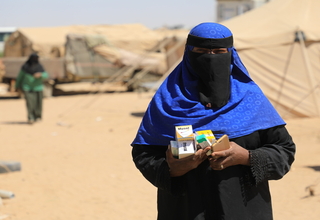 امرأة حامل من النازحين تحمل بين يديها أدوية خاصة بصحة الأم في طريق عودتها إلى المأوى المؤقت الخاص بها في محافظة مأرب- الصورة خاص