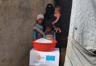 Amina with her children after receiving essential supplies to help the family get through the immediate post-crisis period. © Sh