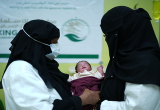 A midwife hands over a newborn to the mother at a KSrelief-supported health facility in south Yemen ©UNFPA Yemen