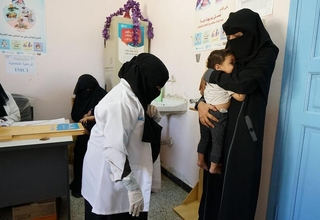 A young mother and her baby are weighed before being examined for malnutrition at UNFPA-supported Marib General hospital in Yemen, a country that relies heavily on food imports. Skyrocketing food prices have increased the number of people in need of food assistance from 16.2 million in 2021 to 19 million people in 2022. © UN/Giles Clarke