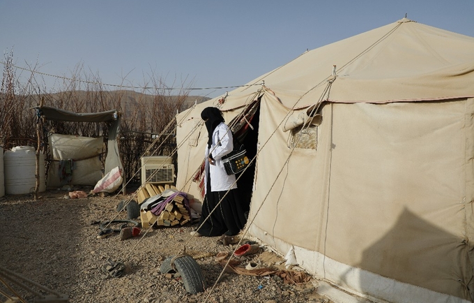 A reproductive health worker exits a tent in a displacement camp where she is providing services. UNFPA is the sole provider of life-saving reproductive health services in Yemen. © UNFPA Yemen
