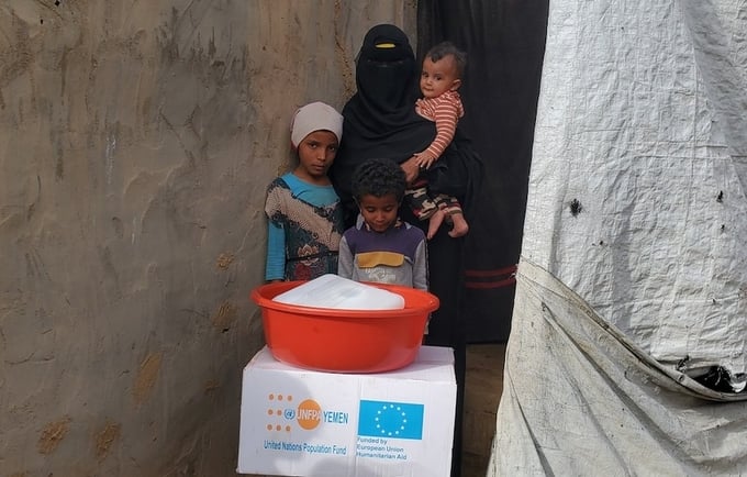 Amina with her children after receiving essential supplies to help the family get through the immediate post-crisis period. © Sh