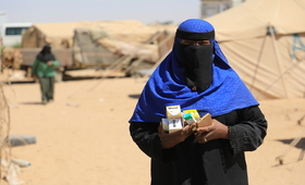 امرأة حامل من النازحين تحمل بين يديها أدوية خاصة بصحة الأم في طريق عودتها إلى المأوى المؤقت الخاص بها في محافظة مأرب- الصورة خاص