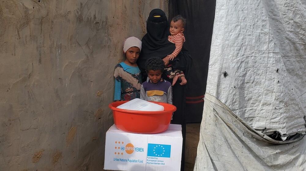 Amina with her children after receiving essential supplies to help the family get through the immediate post-crisis period. © Sh