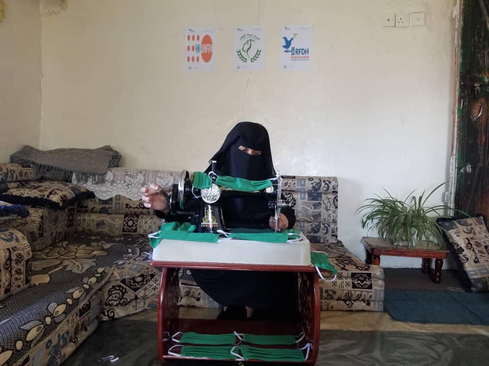 A woman at a safe space in Raymah sews face masks for her community. © RFDH/UNFPA