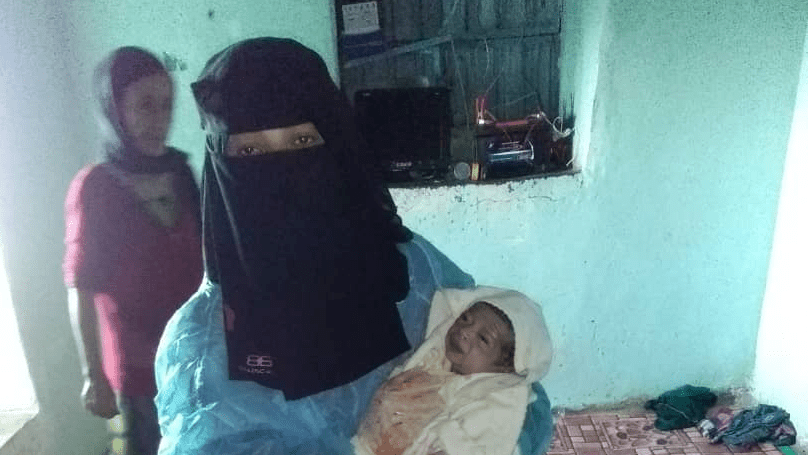 Midwife Lena Al-Shurmani holds Abia's newborn baby shortly after delivery. Abia lost a lot of blood during childbirth. © UNFPA Yemen